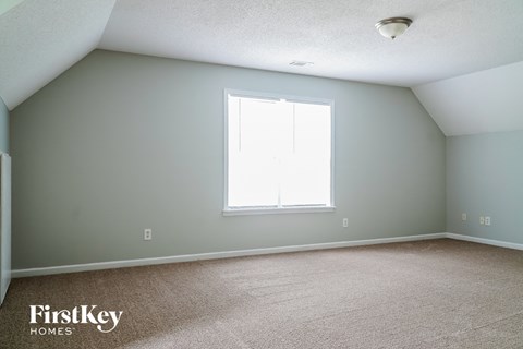 a room with gray walls and a window and a carpeted floor