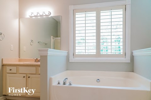 a bathroom with a tub and a sink and a window
