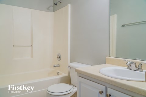 a bathroom with a sink toilet and shower and a mirror
