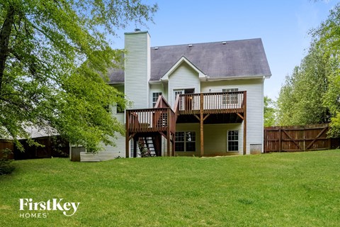 a house with a deck on top of a yard