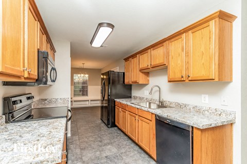 A kitchen with wooden cabinets and granite countertops.