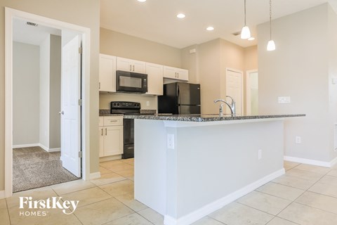 a kitchen with an island with a sink and a microwave