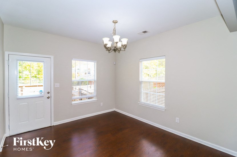 an empty living room with wood floors and a white door