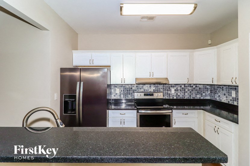 a kitchen with white cabinets and a stainless steel refrigerator