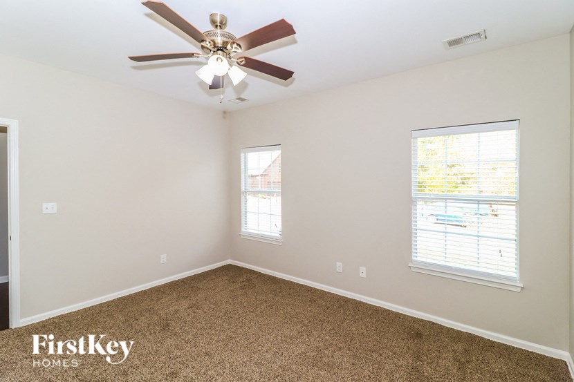a bedroom with a ceiling fan and a window