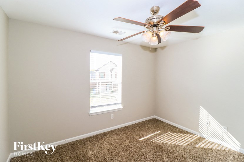 a bedroom with a ceiling fan and a window
