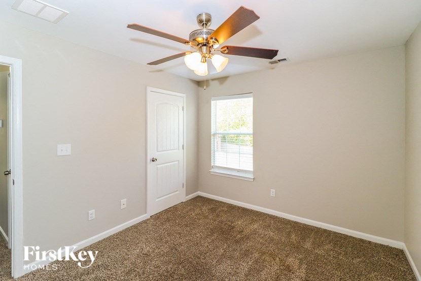 a bedroom with a ceiling fan and a window