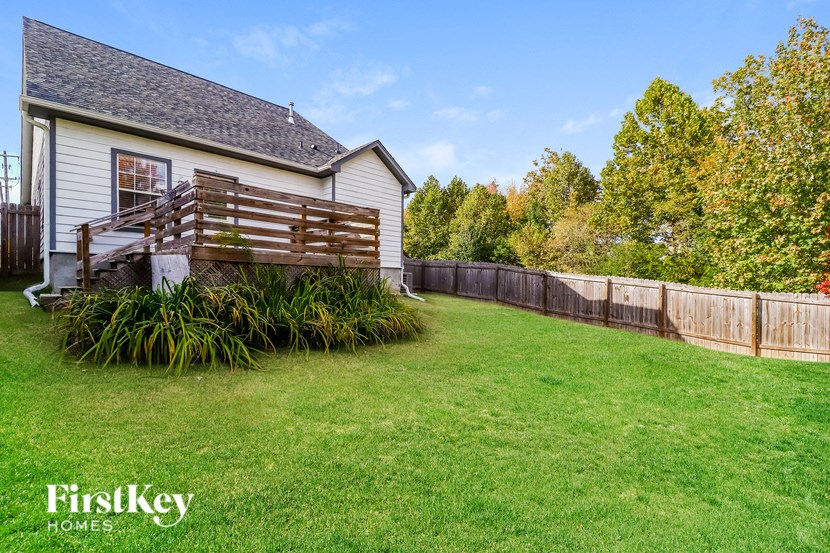 a backyard with a fence and a house