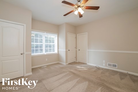 a bedroom with carpet and a ceiling fan