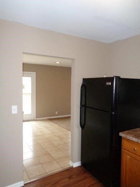 a kitchen with a black refrigerator and a door