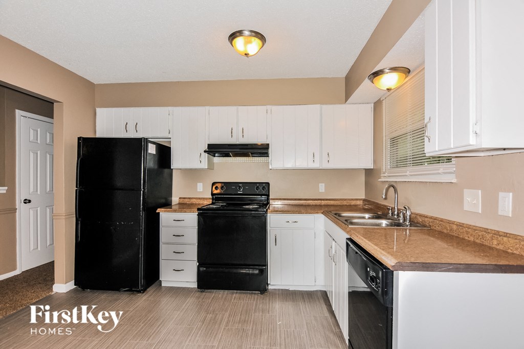 a kitchen with black appliances and white cabinets