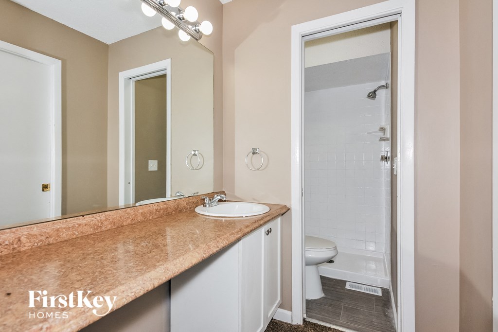 a bathroom with a sink and a shower and a toilet