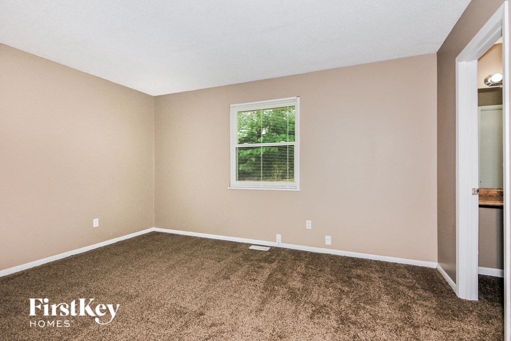 a bedroom with a carpeted floor and a window