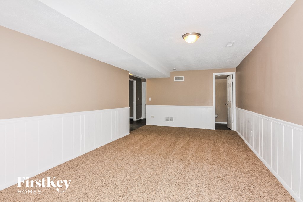 a long hallway with white and brown walls and a carpeted floor