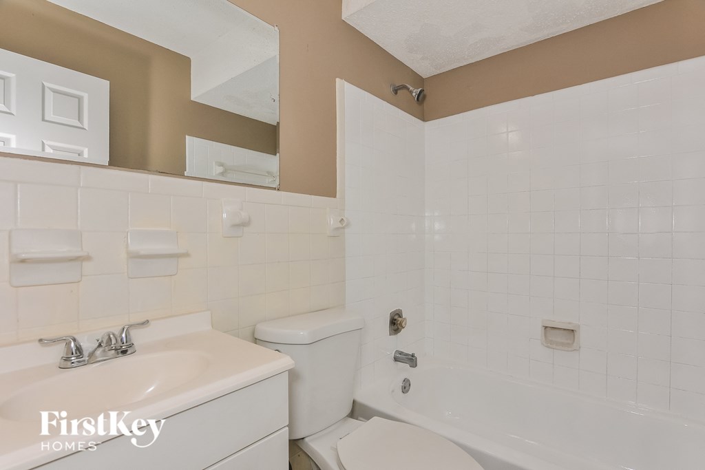 a white bathroom with a toilet and a sink