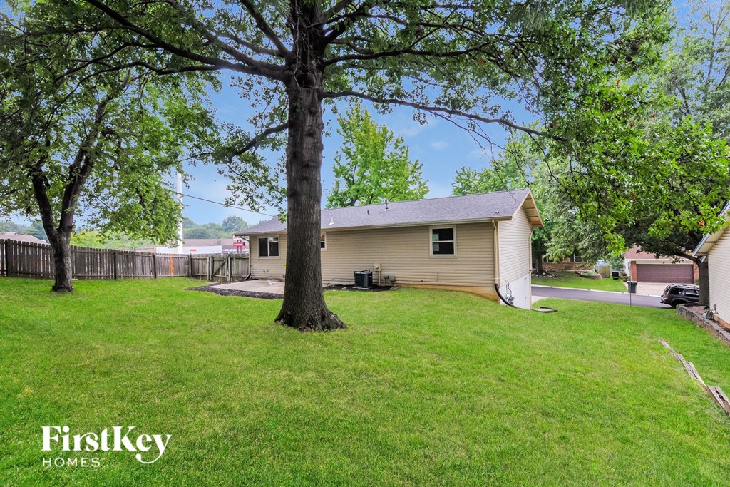 a backyard with a house and a large tree