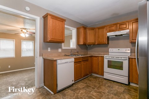 A kitchen with wooden cabinets and a white dishwasher.