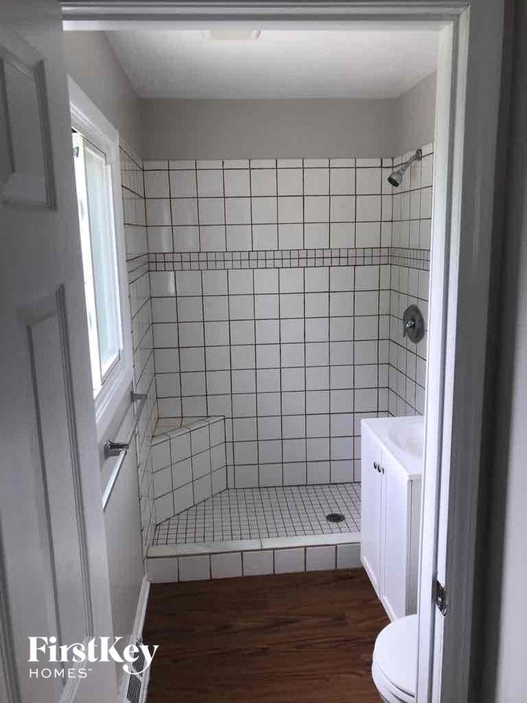 A small white bathroom with a walk in shower.
