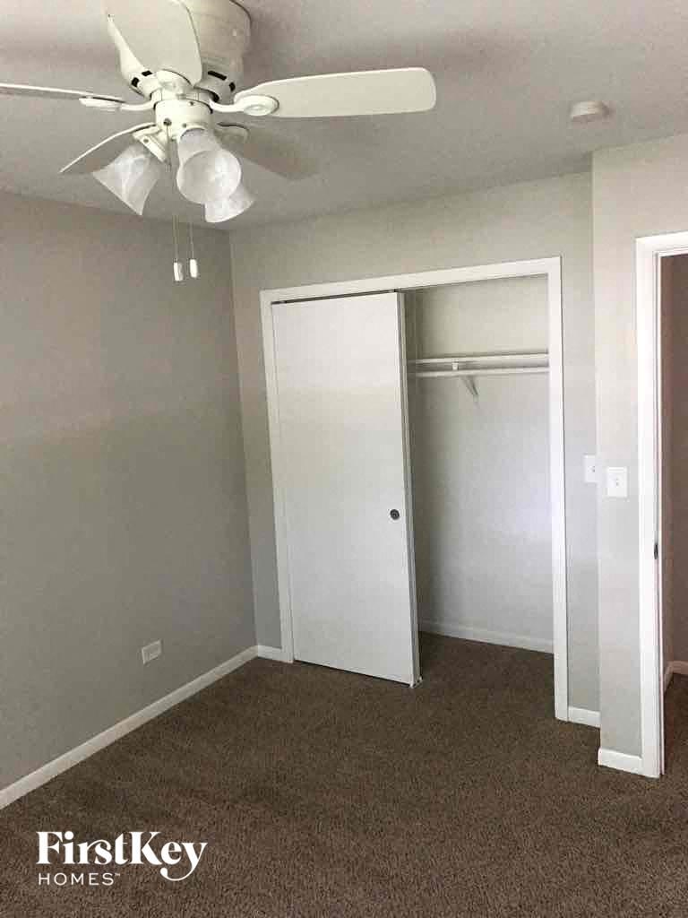 A room with a ceiling fan and a closet.