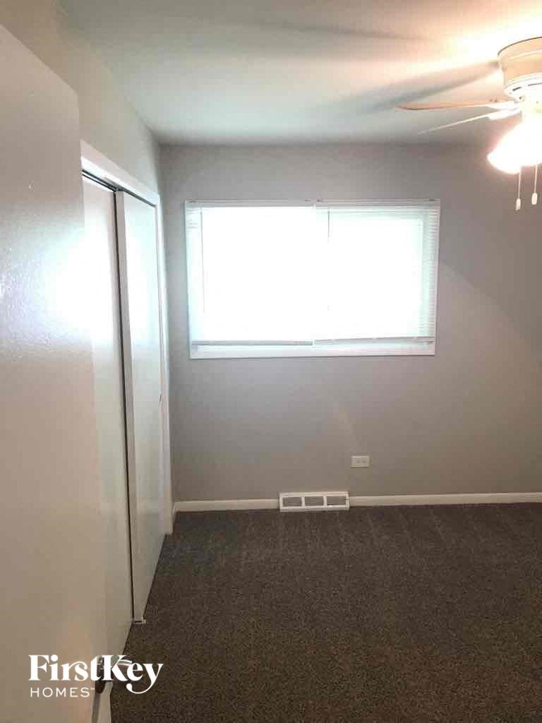 A room with a carpeted floor and a window.