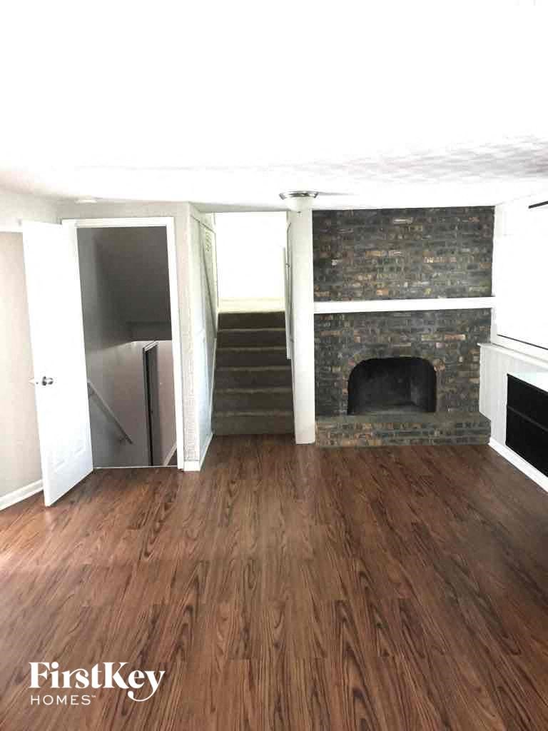 A room with a fireplace and wooden floors.