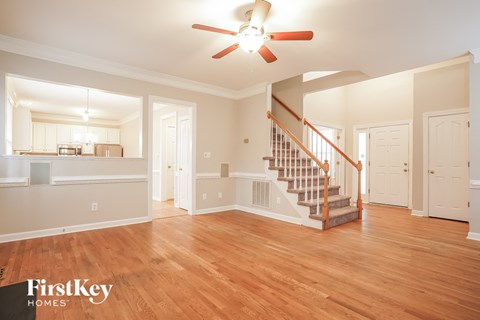 A spacious living room with a staircase leading to the upper floor.