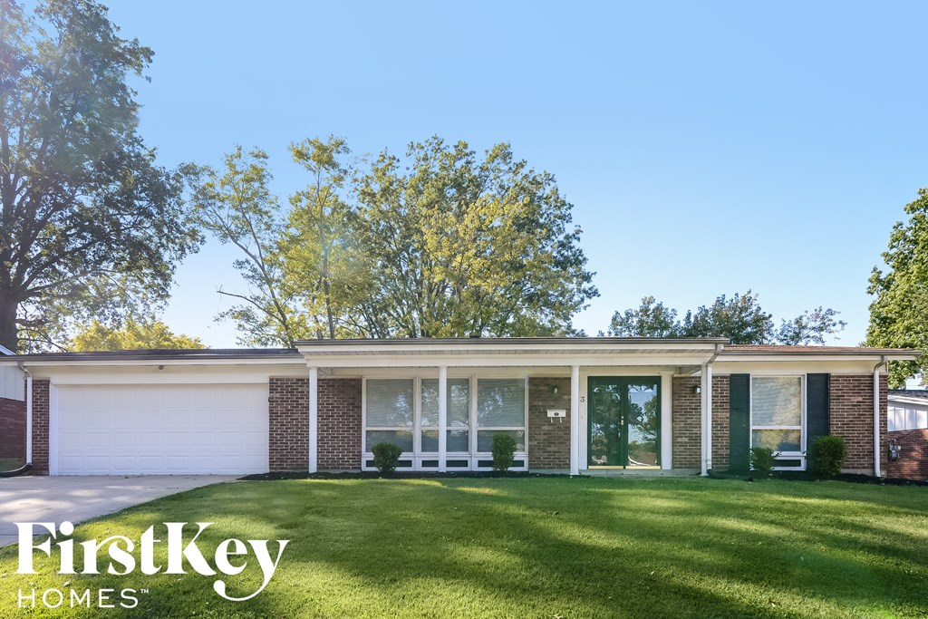 A house with a white garage door and a brick wall.