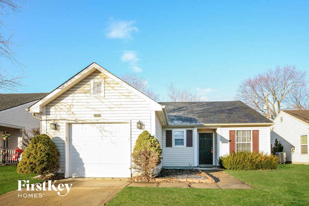 a white house with a garage and a blue sky