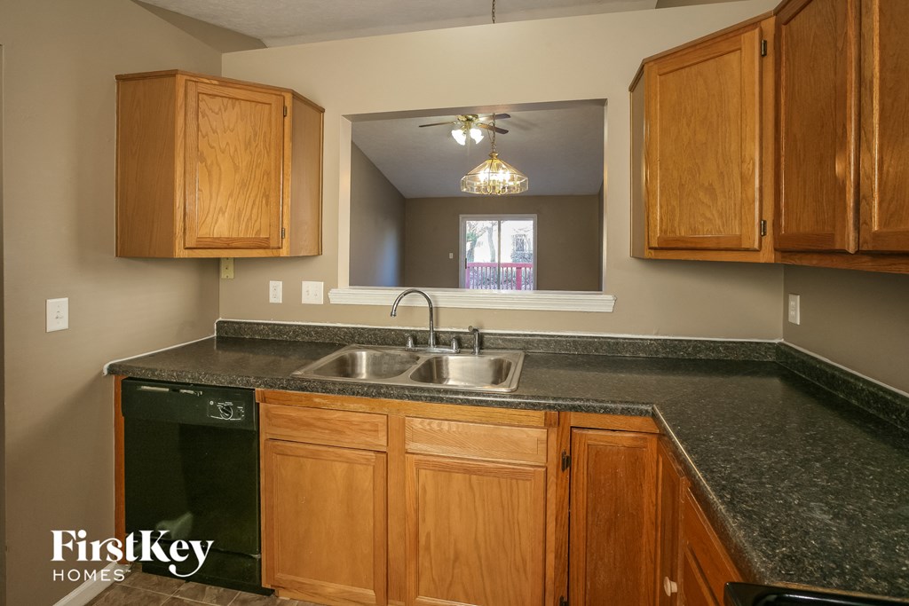 a kitchen with wooden cabinets and black granite counter top and a sink