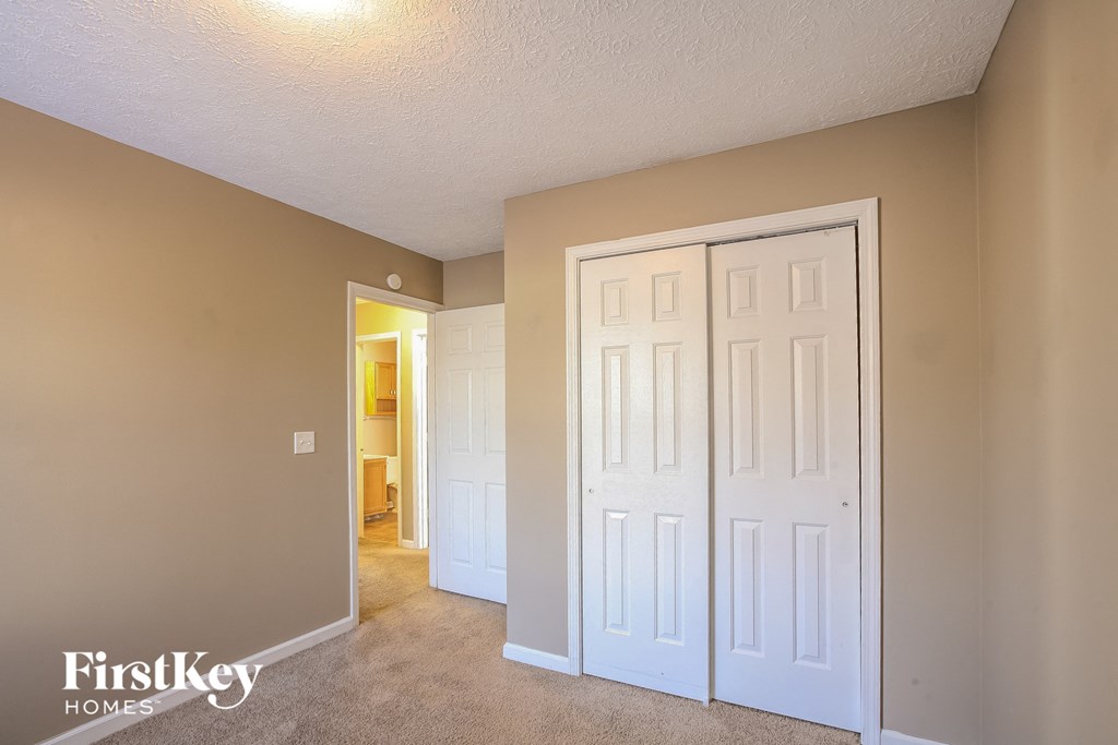 a bedroom with two closets and a door to a hallway