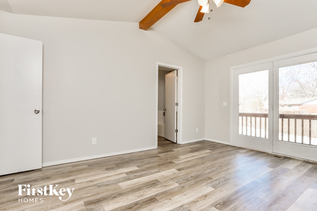 A room with wooden flooring and a ceiling fan.