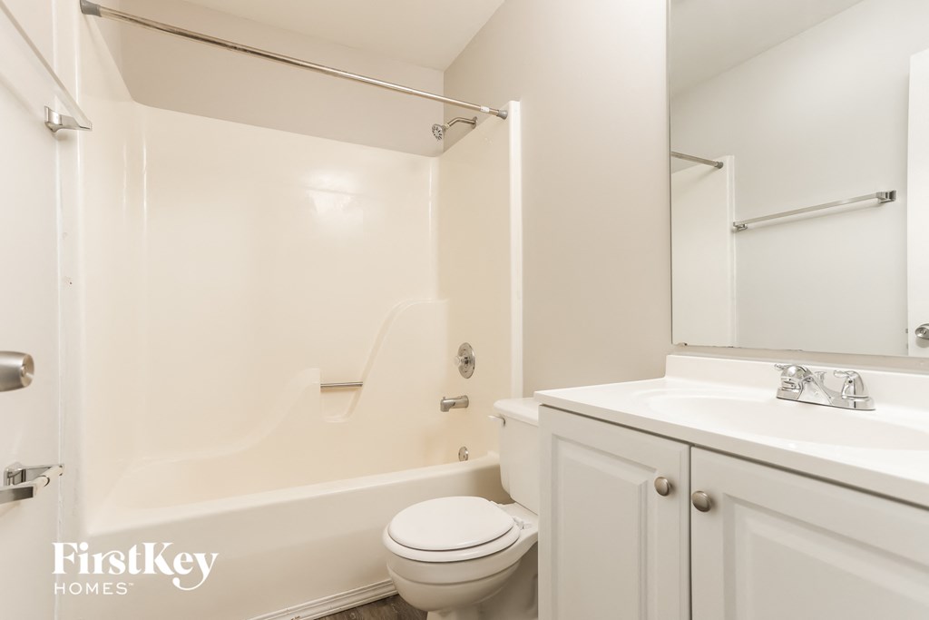 A white bathroom with a toilet, sink, and bathtub.