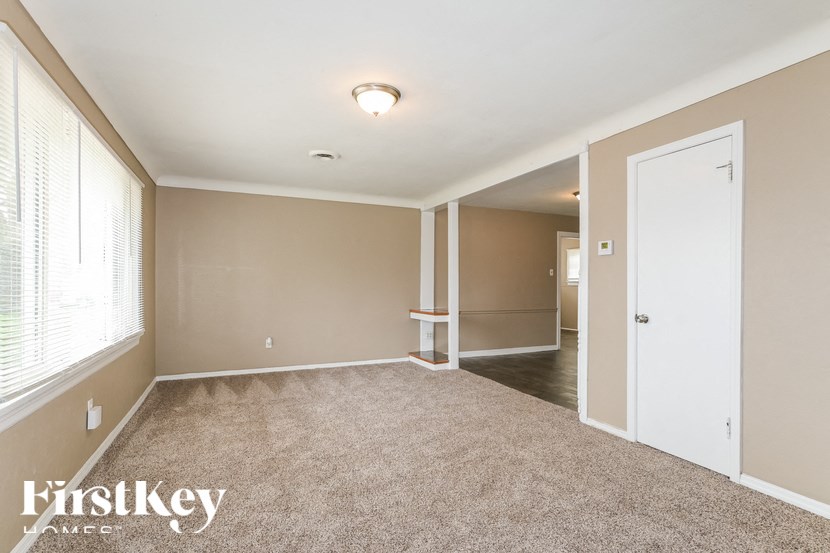a bedroom with a carpeted floor and a door to a hallway