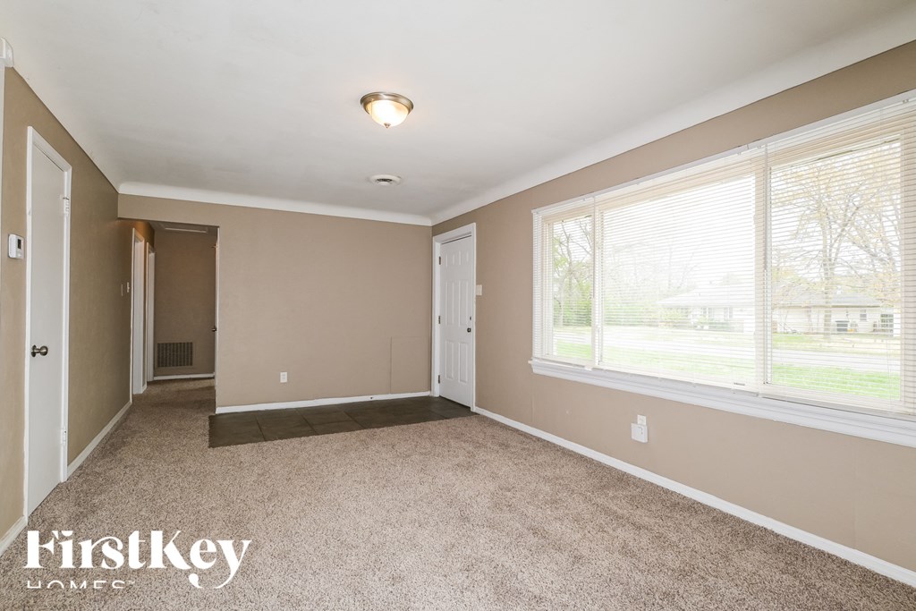 a bedroom with a carpeted floor and two large windows
