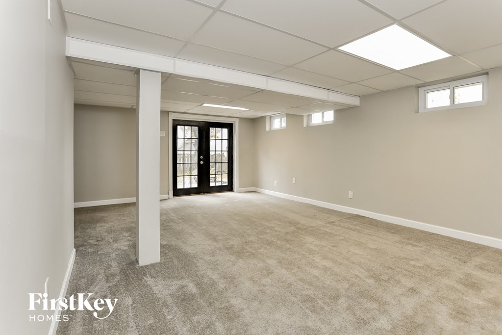 A spacious room with a door at the end and a window on the wall.