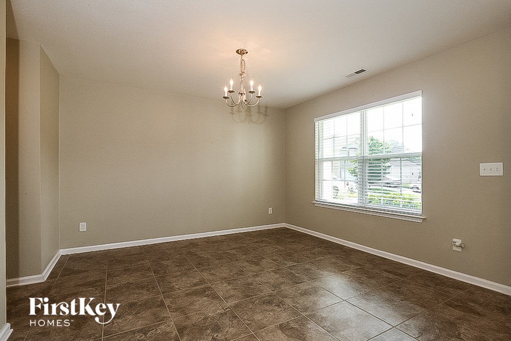 the dining room of a house with a large window
