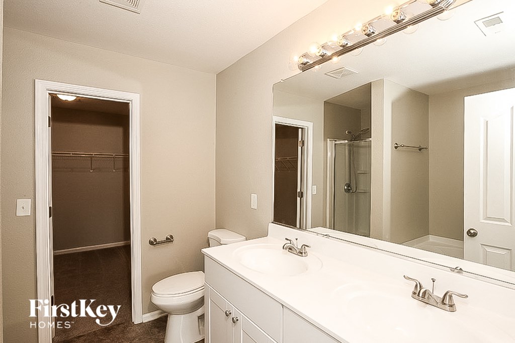 a bathroom with a large mirror and a toilet and a sink