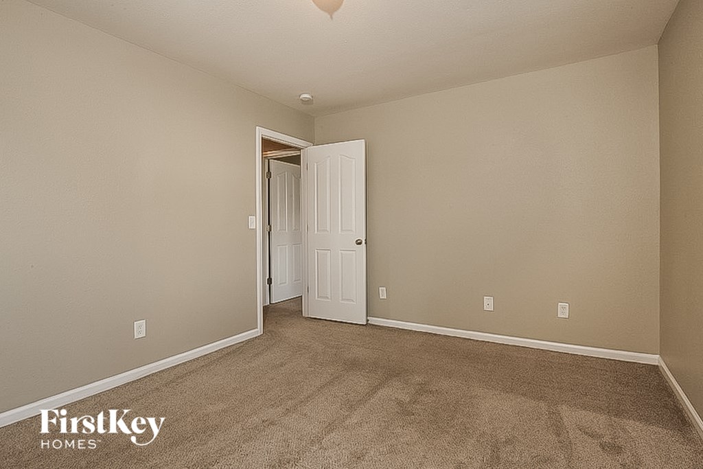 a bedroom with a carpeted floor and a door to a closet