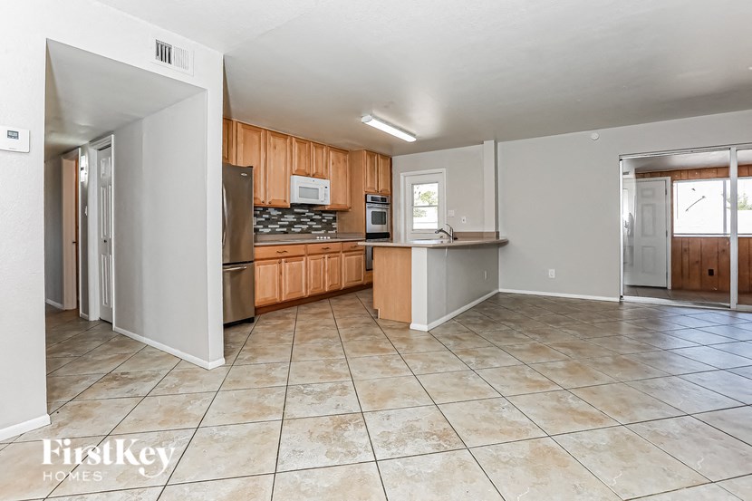 A kitchen with wooden cabinets and a tile floor.