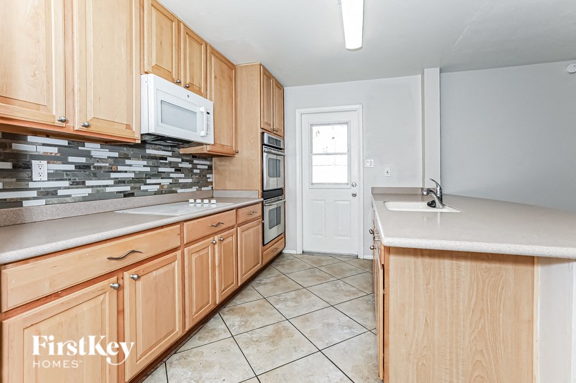 A kitchen with wooden cabinets and a white microwave.