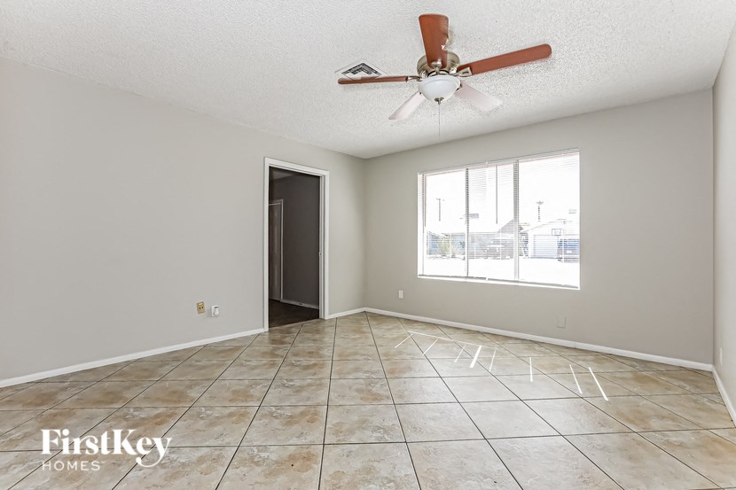 A room with a fan and tile flooring.
