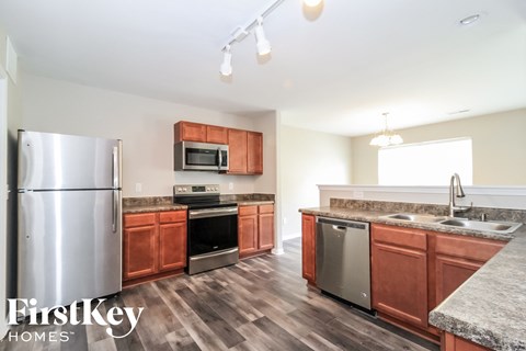 a kitchen with wooden cabinets and stainless steel appliances