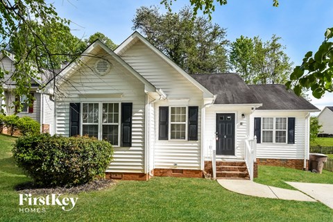 a white house with black shutters and a front yard