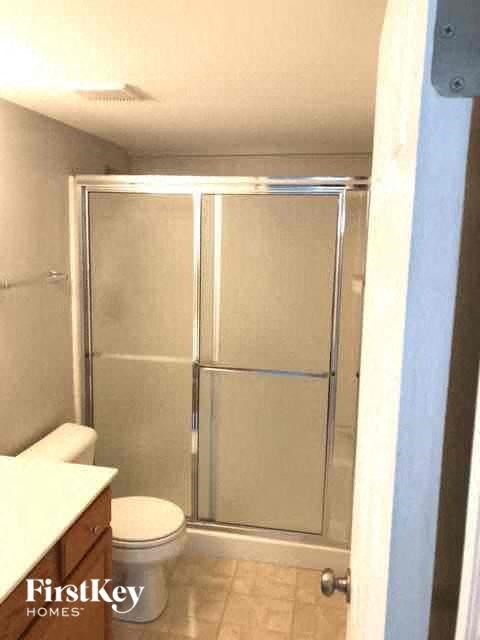 A small bathroom with a toilet and a walk in shower.