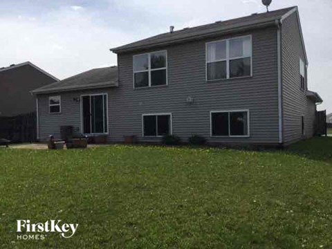 A grey house with a grassy lawn in front.