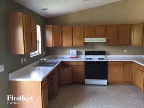 A kitchen with wooden cabinets and a black dishwasher.