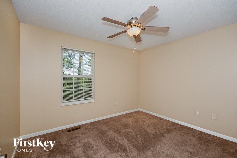 a bedroom with a ceiling fan and a window