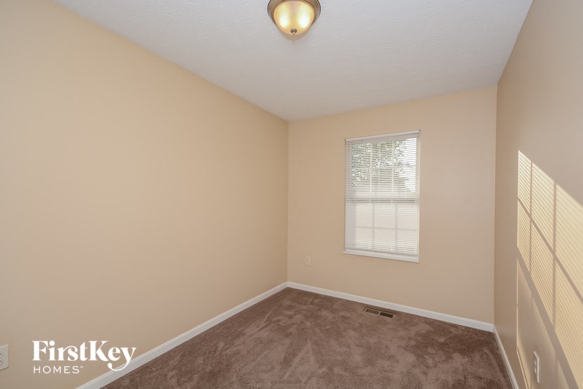 a bedroom with a carpeted floor and a window