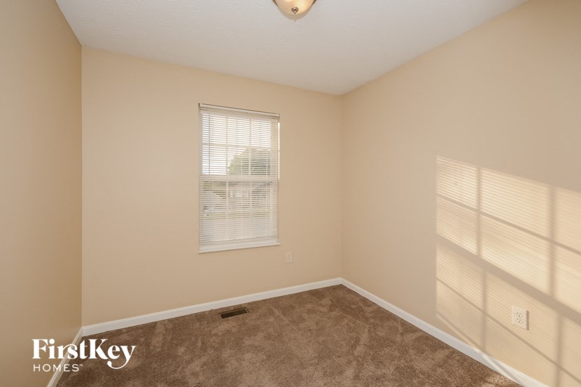 a bedroom with a carpeted floor and a window