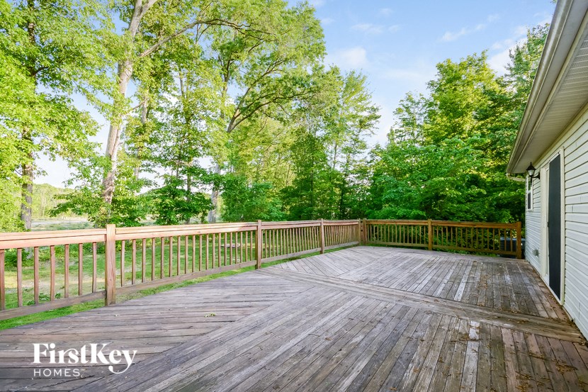 a deck with trees in the background and a lake
